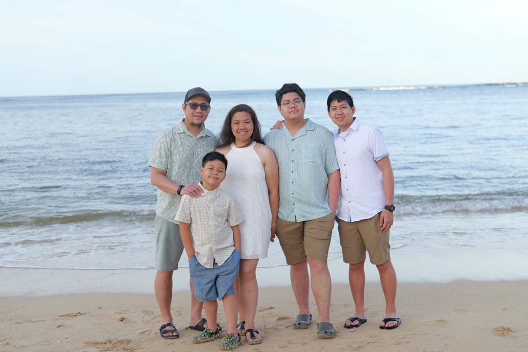 The Traveling Californian family smiling together on a Hawaii beach